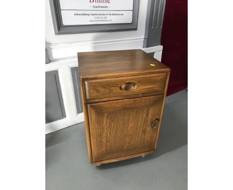 An elm wood ercol bedside cabinet designed with single drawer and door. Measures 68.5x46.5x45.5cm 