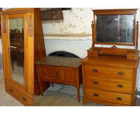 An early 20th Century walnut three piece bedroom suite, comprising single mirror door wardrobe, mirrored back dressing table,