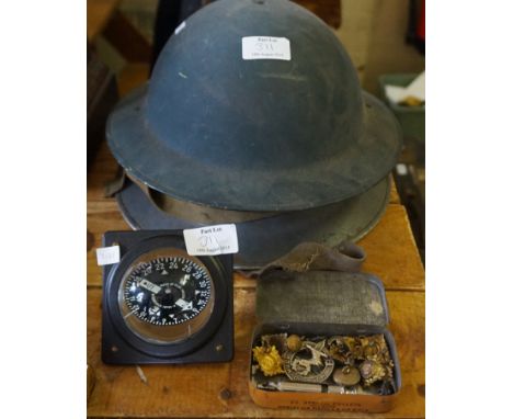 A mixed lot to include two military helmets, one with a Belgian flag, a part of a gimbal compass, assorted military cap badge
