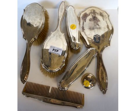 A London hallmarked silver backed dressing table set comprising hand mirror, two clothes brushes, two hairbrushes and a hair 