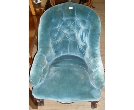 A Victorian ladies nursing chair upholstered in a button back material, raised on scrolling supports.