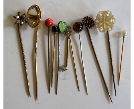 Seven assorted hat pins, to include an example with a amber stone, an example with a jade love heart, a mother of pearl termi