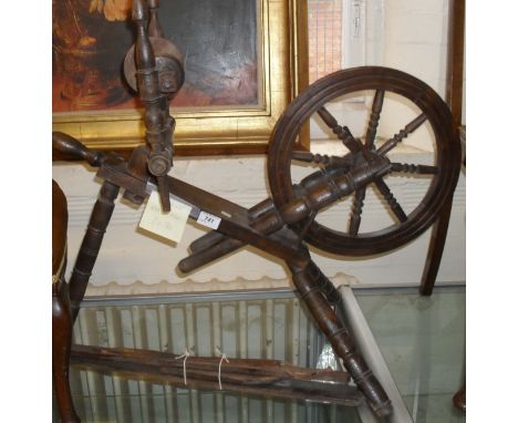 A 20th Century rustic spinning wheel and a 20th Century brass fender.