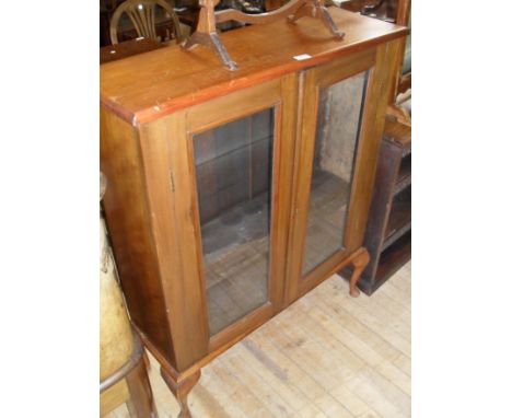 A stained pine twin door display cabinet having single adjustable shelf.