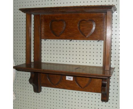 An Arts & Crafts possibly Scottish oak hanging shelf, with four carved love heart panels. CONDITION REPORT: Lot 745: conditio