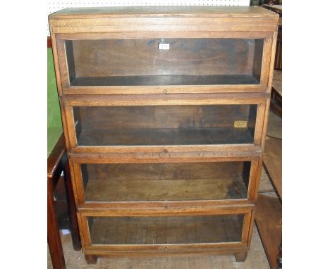 An early to mid 20th Century light oak four tier Globe Wernicke bookcase having up and over glazed doors.