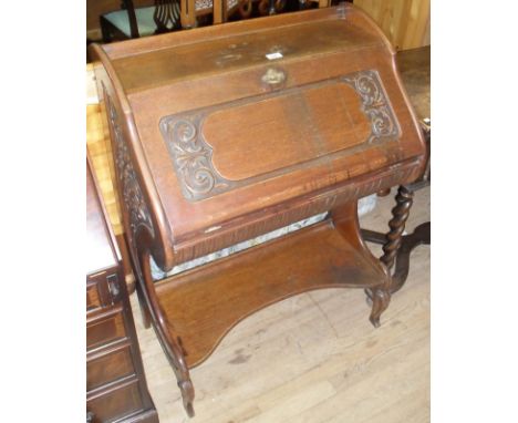 An early 20th Century oak bureau, the carved fall front enclosing fitted interior, with undertier shelf.