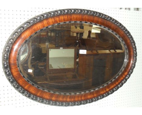 A stained carved wall mirror, having bevelled edged plate.