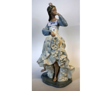 A Nao Lladro figure of a girl with flower in her hair with blue polka dot dress.