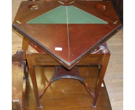 An Edwardian mahogany folding envelope card table, raised on tapering block supports.