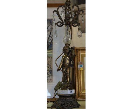 A modern gilt metal table lamp depicting a cherub, below glass top section. 
