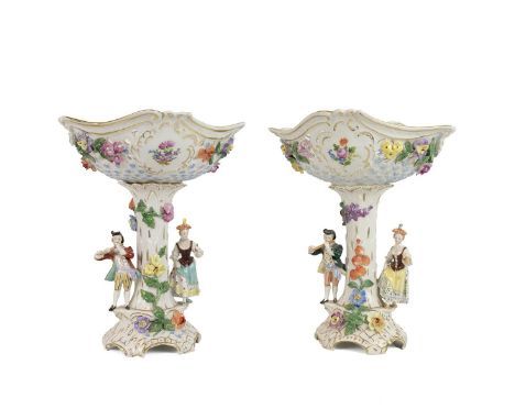 Two late 19th century Dresden pierced comports, each column flanked with figures of a gentleman playing a flute and a lady re