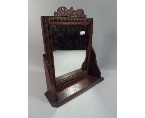 A Carved Oak Hall Mirror with Shelf.