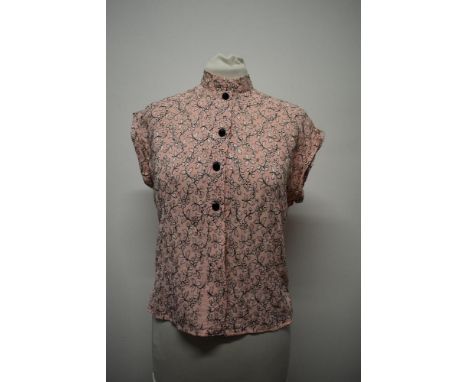 A pale pink 1950s blouse, having machine embroidered floral pattern in black with black buttons, turn up cuffs to sleeves and