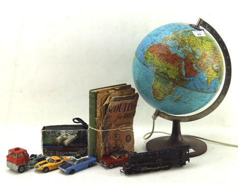 A collection of toys, including a desktop revolving atlas lamp, die cast cars and two early scouting books