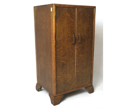 A 20th century oak two door cabinet, containing a single shelf, on bracket supports, L42cm x D35.5cm x H82cm