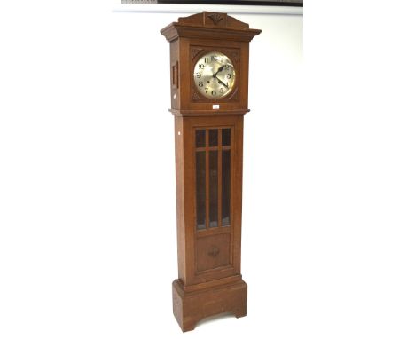 An early to mid-20th century oak and glazed longcase clock, fan-shaped relief details, Arabic numerals to the face denoting h