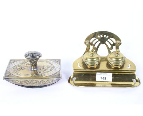 An Art Noveau brass inkwell with a blotter, each cast with scrolls, the inkwell with two integral inkwells with ceramic liner