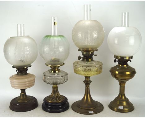 Four Victorian and later oil lamps, with metal, glass and ceramic reservoirs and bases, all with glass shades, height of tall