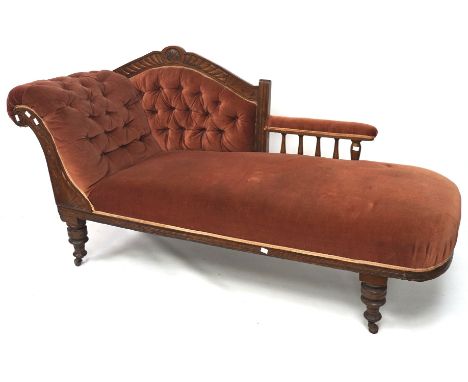 An Edwardian oak framed chaise longue, with button back rest, raised on turned supports to castors, L165cm x W62cm