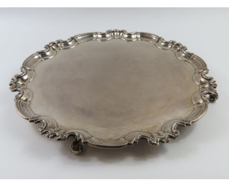 A large silver salver with smooth plate and perpetual ogee-shaped border decorated with flora. Made by William Hutton & Sons,