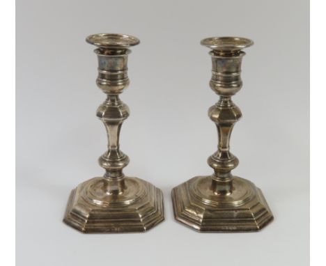 Two silver candlestick holders with graduated octagonal base and decorative spine extruding from a central ripple. Made by Th