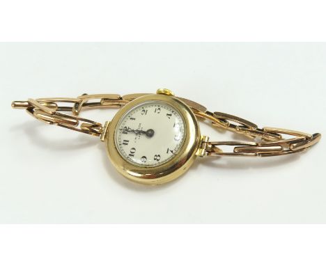J W Benson - a ladies 9ct gold manual wind watch face, the round cream dial with black Arabic numerals and blue steeled hands
