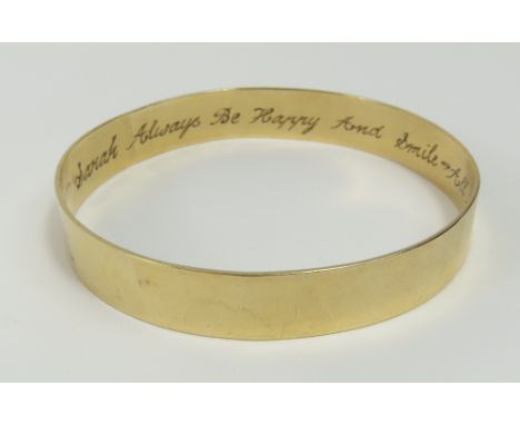 A plain, solid bangle, with inscription internally ' Sarah Always Be Happy And Smile-All My Love-Simon 5-4-93', marked '9ct 3