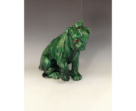 A Bretby model of an injured bulldog, he sits with wearing an eye patch and lifting his paw, green glaze, sgraffito marks, 25