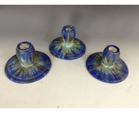 A set of three Bretby circular boudoir candlesticks, glazed in mottled tones of cobalt blue, light blue, yellow and orange, 8