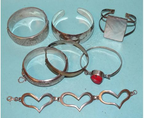 Two silver hinged bangles, a beaten 925-silver bangle and four other silver bracelets, (two set stones), gross weight 5.13oz,