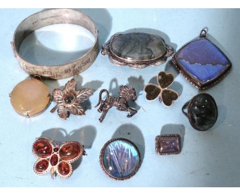 A silver hinged bangle, Birmingham 1978, a large silver-mounted moss agate ring and similar brooch, three butterfly wing broo