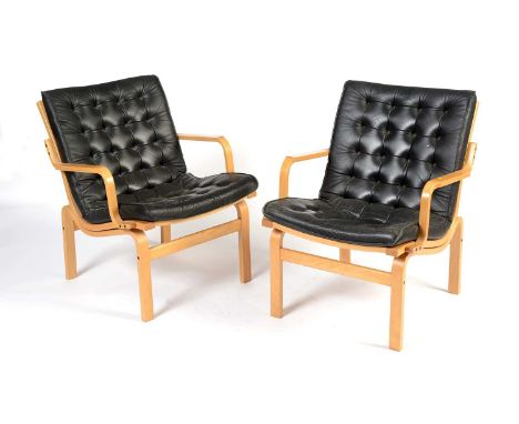Nielaus Mobler of Denmark: a pair of mid-Century teak and black leather button back lounge chairs, the curved elbow rests rai