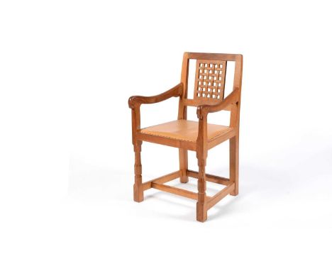 A Robert 'Mouseman' Thompson of Kilburn: an oak carver chair, the lattice backrest, over a cushioned seat upholstered in tan 