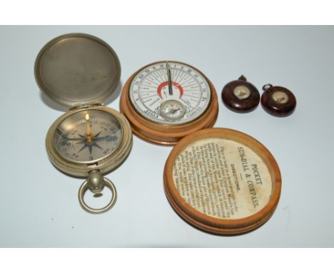 A fruitwood cased pocket sundial  and compass; another cased compass stamped  U.S; a bakelite cased compass; another (4)