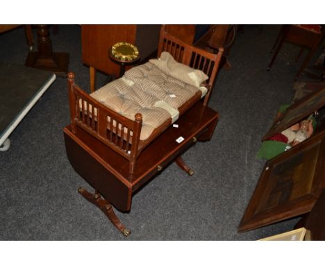 A twentieth century mahogany sofa table/occasional table, two drawers to frieze;  a dolls bed (2)