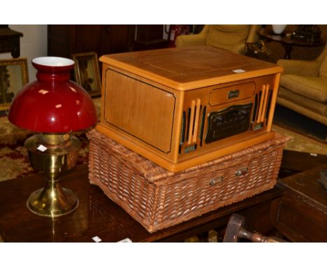 A wicker picnic hamper;   linen and lace, some embroidered;  a Dalkin record player;  a brass oil lamp