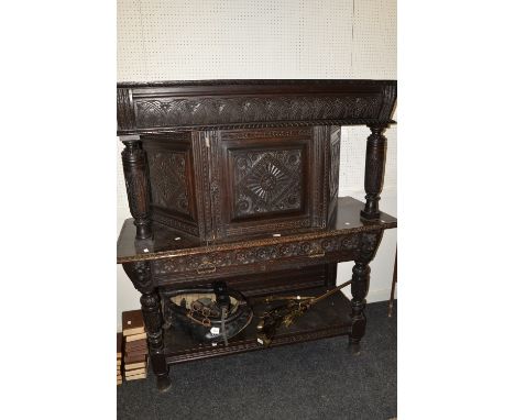 A Victorian carved oak buffet, in the 17th century style, the canted top with turned pilasters, the projecting base with two 