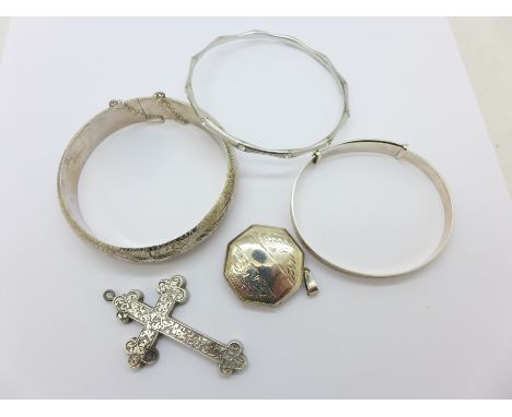 Two silver bangles, one other bangle, a cross pendant and a silver locket