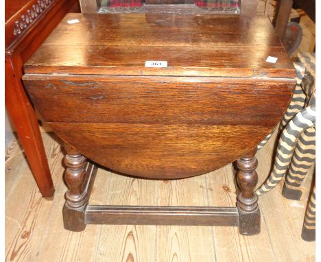 A 19" 1920`s stained oak joint stool style drop-leaf low table with swivel action, set on turned supports