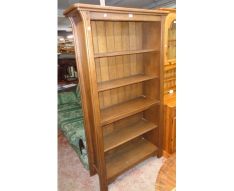 A 3' 6" modern polished oak and mixed wood five shelf open bookcase in the Arts &amp; Crafts style, set on moulded feet