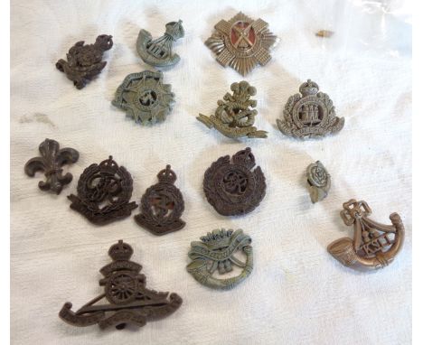 Fourteen British Army bakelite economy cap badges including Royal Scots, Military Police, Royal Artillery, Intelligence Corps
