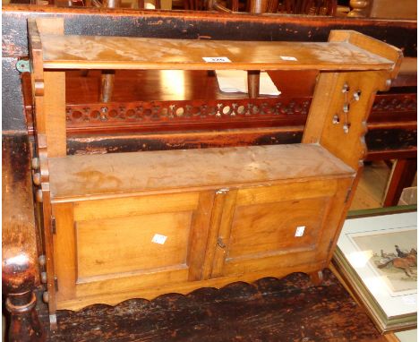 A 22 1/2" late Victorian wall mounted cabinet with shelf top, pierced ends and pair of panelled cupboard doors under