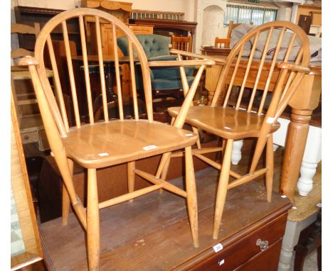 A pair of Ercol style light elm seated elbow chairs with hoop stick backs and simple turned supports