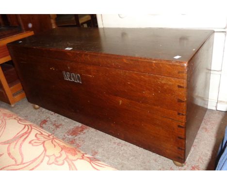 A 4' early 20th Century polished oak storage trunk, set on Shepherd castors