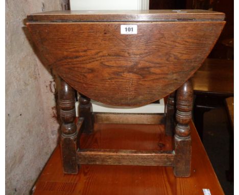 A 19 1/2" 1920`s oak joint stool style drop-leaf table, set on turned supports