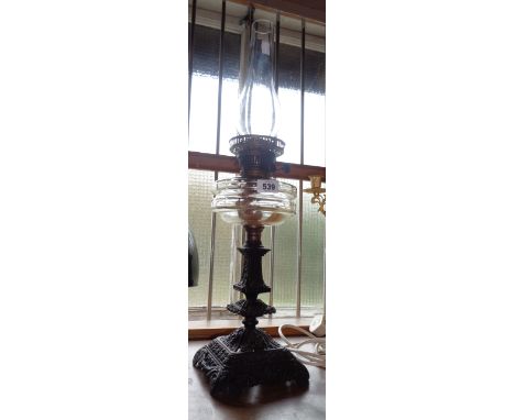 A Victorian table oil lamp with ornate cast iron base