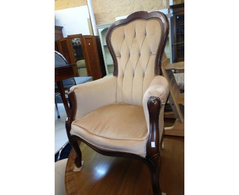 A late 20th Century button back fireside armchair in the Victorian style with part show frame and studded frosted peach velou