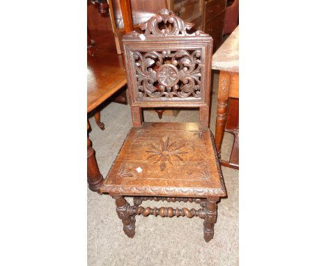 A Victorian carved and polished oak hall chair with decorative pierced acanthus scroll and boss back panel, set on barley twi