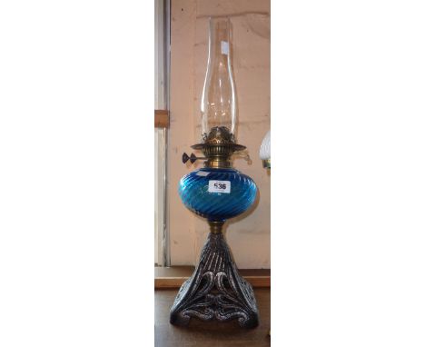 A Victorian table oil lamp with ribbed blue glass reservoir and cast iron base